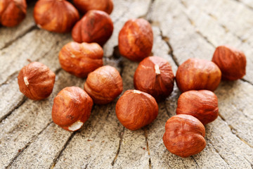 Hazelnuts on rough wooden background.