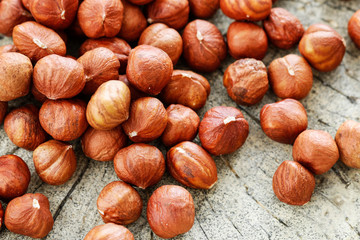 Hazelnuts on rough wooden background.