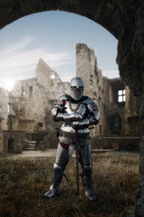 Fototapeta premium Knight in armor and helmet poses in castle