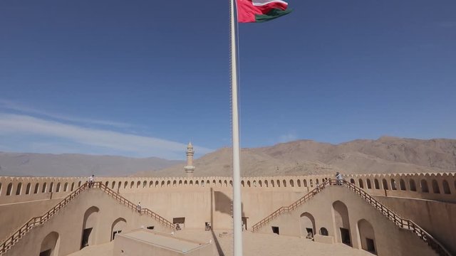 Nizwa Fort, Oman - February 2019. Traditional Omani fortress, general plan and details, guns and a flag on the main tower.