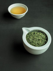 A cup of tea made from dry thyme (thymus serpyllum) on black background.