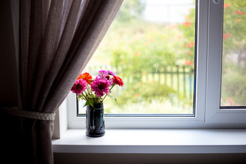 Flower bouquet of autumn chrysanthemum in vase on the window of the living room