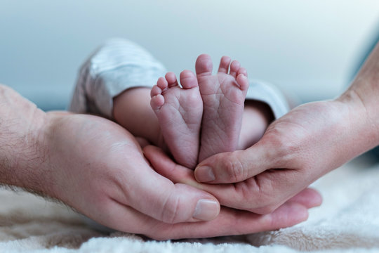 Mother and father hold the baby's feet, Newborn Baby's feet ,Tiny feet in hand.