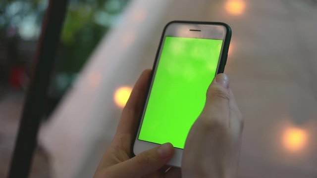 Close up woman hands use smartphone on wigwam background on villa cottage green screen chroma scroll social media 5g