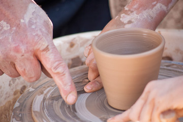 A potter craftsman transfers his skills to a student