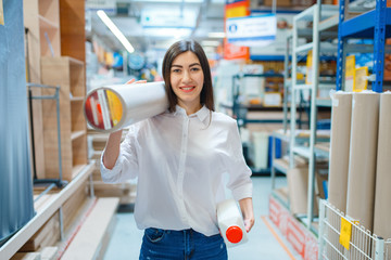 Female consumer buying wallpapers, hardware store