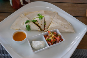 Chicken quesadilla with salsa and cheese.  Mexican cuisine, food background.