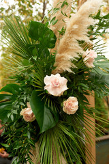 Composition of pampas grass, palm trees and roses. Decorative floristry