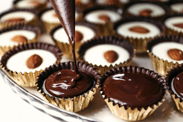 Fototapety  Ganache czekoladowe z migdałami. Wylewanie czekolady, domowy deser.