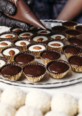 Chocolate ganache candy with almonds. Pouring chocolate, homemade dessert.