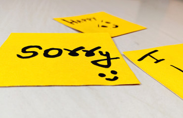 The word "Sorry" written on yellow paper