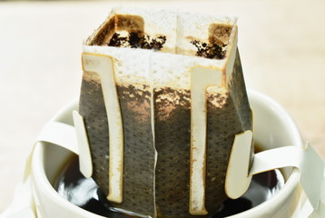  coffee drip mixed by hot water pouring from ceramic jar on cup