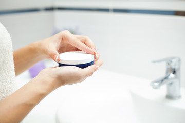 Skin care. Woman use skin care products at home in light bathroom