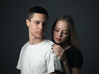 Young gentle couple in love posing in studio.