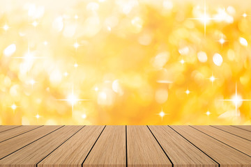 abstract blur beautiful gold color and glittering bokeh light background with modern brown wood tabletop for show,ads,design product on display in the christmas festival and happy new year season