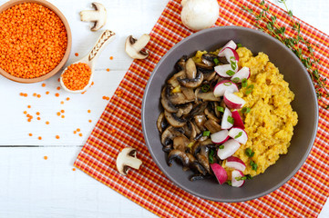 Lentil porridge with mushrooms, radish in a bowl on a white background. Dietary, lean menu. Vegetarian dish. Top view.
