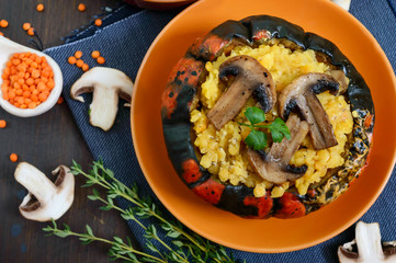 Lentil porridge with mushrooms in a pumpkin pot. Dietary, lean menu. Vegetarian dish. Top view.