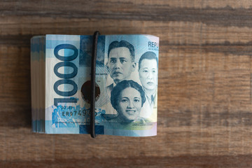 Folded bundle of money in cash of one thousand Philippines peso. Bribe, investment, paying bills or getting salary. 