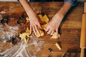 Young adult woman cooking holiday cookies in winter season at home