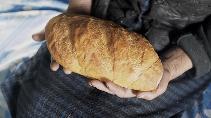 Grandmother holds a freshly baked bread