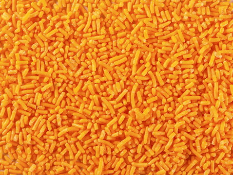 Orange chocolate sprinkles, granules  background and texture, top view
