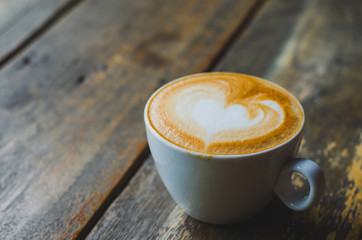 close up modern hot black coffee the cappuccino on wood background with coffee bubble foam pattern and texture in white cup looking and feel so delicious on glasses table in coffee shop.