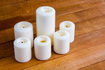 Large white candles on a wooden table