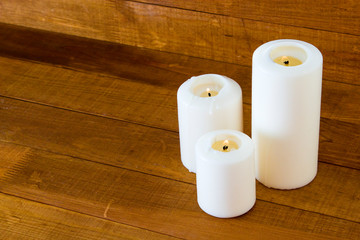 Large white candles on a wooden table