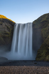Obraz premium Skogafoss waterfall in Iceland on a beautiful summer day with blue sky in the back.