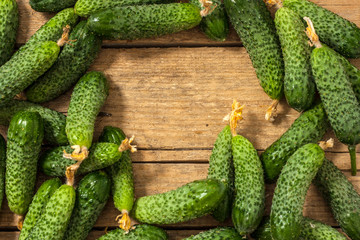 Background of green cucumbers on a wooden table. Organic food. Agricultural retailer. Farm food.Copy space