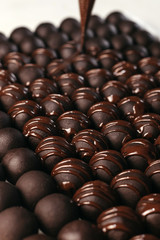 Round chocolates candy. Dark background, luxury dessert, dark chocolate, handmade. Vertical photo.