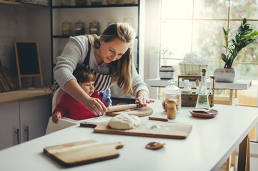 Happy family in the kitchen. Mother and daughter are preparing the christmas cookies.