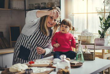 Happy family in the kitchen. Mother and daughter are preparing the christmas cookies.