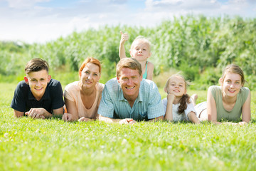 Portrait of large family lying on green lawn outdoors