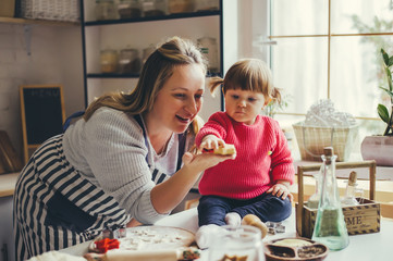 Happy family in the kitchen. Mother and daughter are preparing the christmas cookies.