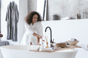 Woman checking on the running water temperature