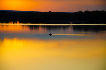 sunset on the lake and the boatman swims