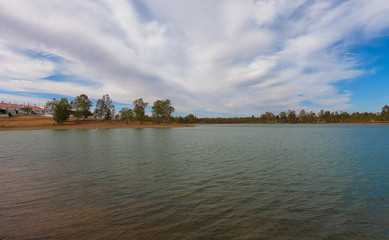 Obraz premium View from a lake with isle with trees in background. Alentejo Portugal