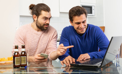 Two men friends are talking and drinking beer