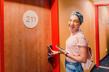 Asian woman entering hotel room using code pad at the door