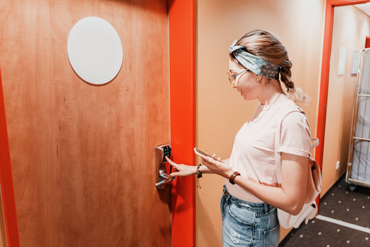 Asian woman entering hotel room using code pad at the door