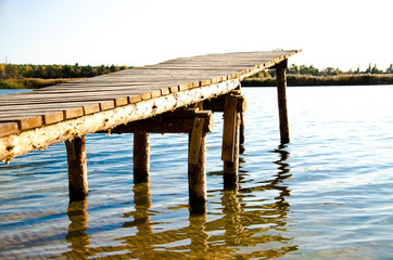 wooden bridge on the lake on a summer day with a blue ode