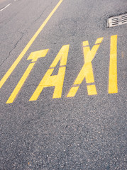 Yellow Taxi sign on blacktop in the city center