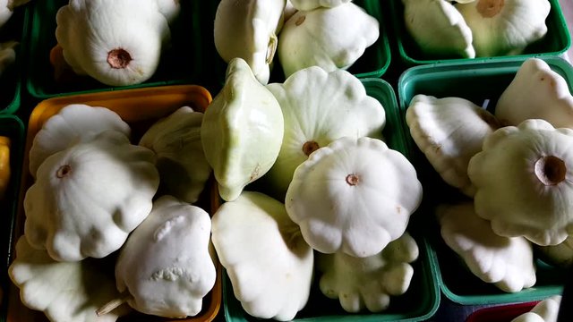 close up shot of a lovely looking white and yellow bumpkin like kind of vegetables kept in plastic boxes for sale in market. lovely, adorable.