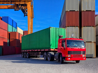 The RTG(Rubber Tried Gantry Cranes) pick up full loaded containers on truck at container yard  and...