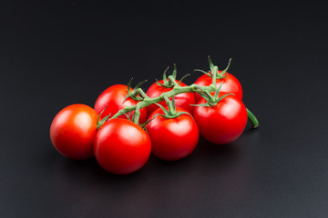 Beautiful red tomatoes on a black background, close up.