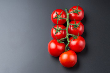 Beautiful red tomatoes on a black background, close up.