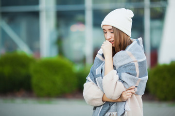 Cold and flu. Woman with flu outdoors dressed in cap