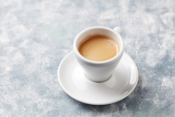 Cup of coffee on bright wooden background. Copy space.