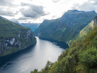 Obraz na płótnie Canvas View on Geirangerfjord in Sunnmore region, Norway, one of the most beautiful fjords in the world, included on the UNESCO World Heritage. View from Ornesvingen eagle road viewpoint, early autumn